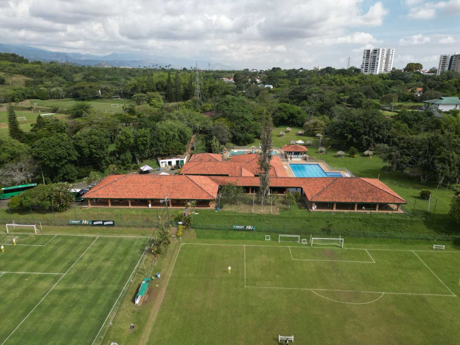 Aerial view of Deportivo Cali's sports facilities with football pitches, buildings and a swimming pool