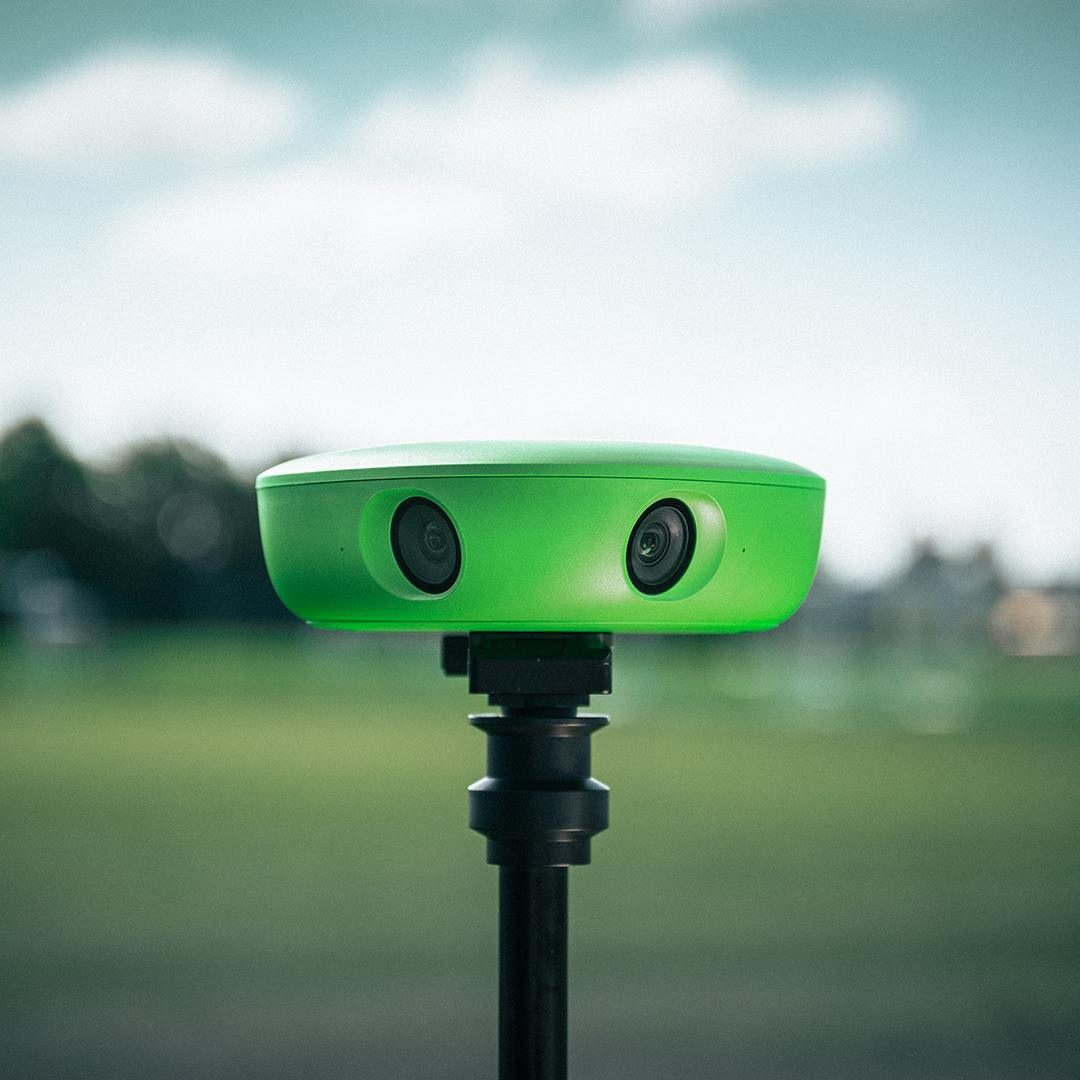 Veo automated sports recording camera mounted on a tripod beside a football pitch
